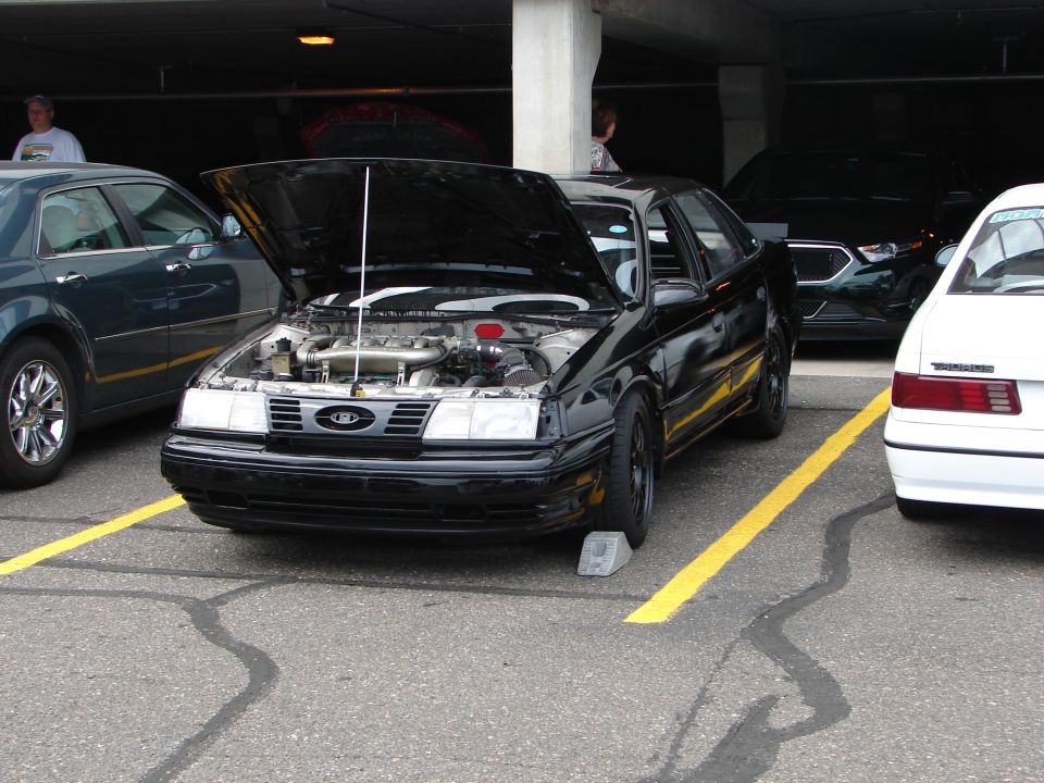 1992 Ford Taurus with hood open, parked next to other cars