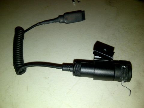 1989 Ford Bronco - A black electronic device with a coiled cord and a mounting bracket is shown on a textured surface.