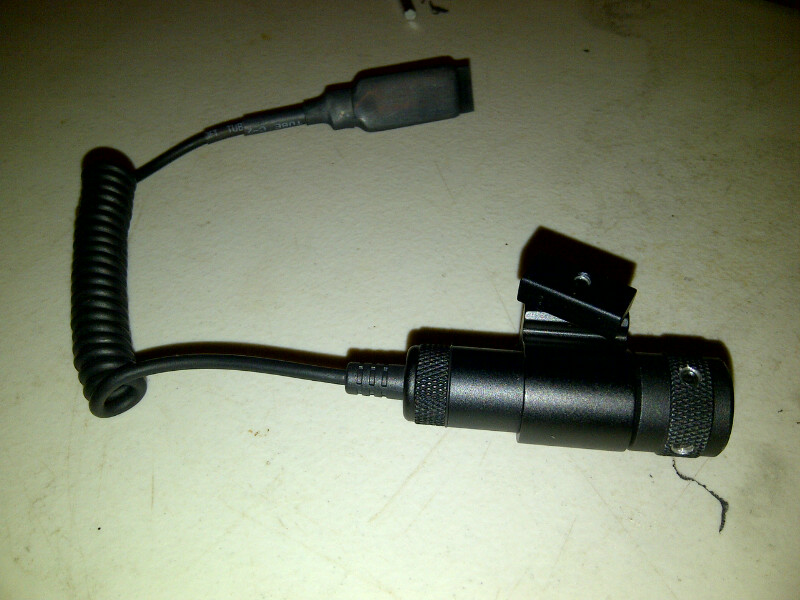 Black electronic device with coiled cord and mounting bracket. Visible text: SUPERMOTORS