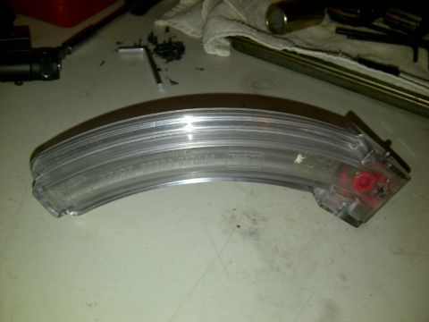 1989 Ford Bronco - A clear turn signal lens is shown, with text imprinted on its surface and red components visible inside.