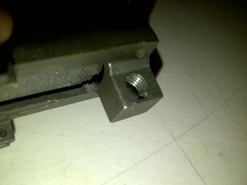 Close-up of a metal bracket with a threaded hole. Supermotors.net logo visible