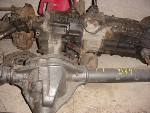 1992 Ford Bronco - Several vehicle drivetrain components are laid out, including a transmission and axles.