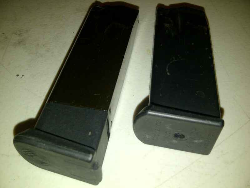 Two black pistol magazines on a surface. One is longer than the other