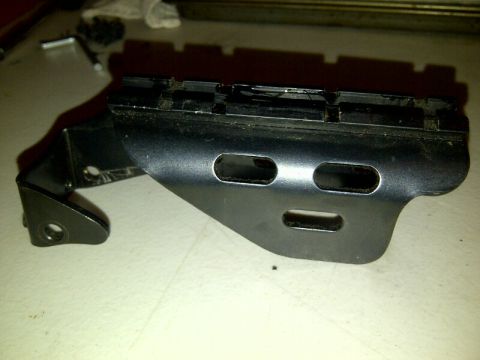 1989 Ford Bronco - A black metal bracket with a rail and cutouts is shown, likely a vehicle part.