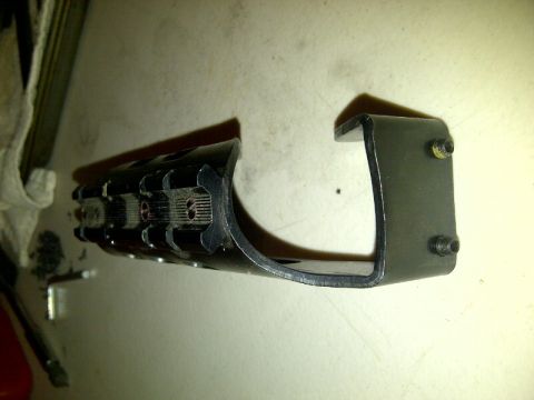 1989 Ford Bronco - This is a metal bracket with a black ribbed component, possibly a car part.