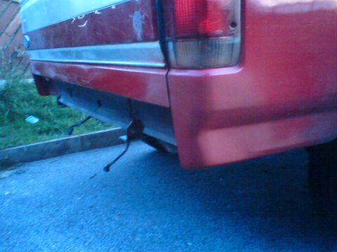 1989 Ford Bronco - Close-up view of the rear bumper and taillight of a red vehicle, with a watermark at the bottom right.