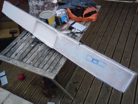 1989 Ford Bronco - A car part is being worked on outdoors, with paint cans and other supplies nearby on a wooden deck.