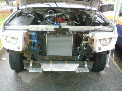 1989 Ford Bronco - Front view of a 1989 Ford Bronco with the hood up, revealing the engine and radiator.