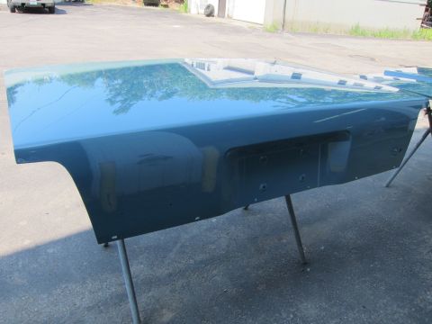 1991 Ford LTD Crown Victoria - Teal painted car fender and hood panel supported by stands outdoors.