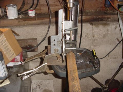 1992 Ford Bronco - A drill press is used to work on a metal pipe, with various tools and materials in the background.