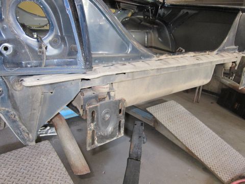 1991 Ford LTD Crown Victoria - The rear quarter panel and fuel tank area of a dark blue vehicle are visible, showing signs of repair or disassembly.