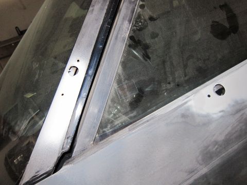 1991 Ford LTD Crown Victoria - Close-up of a car's windshield trim and dusty glass, showing areas prepared for paint.