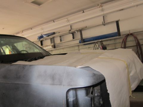 1991 Ford LTD Crown Victoria - A car's front end is covered with paper, possibly for painting or protection, in a garage setting.