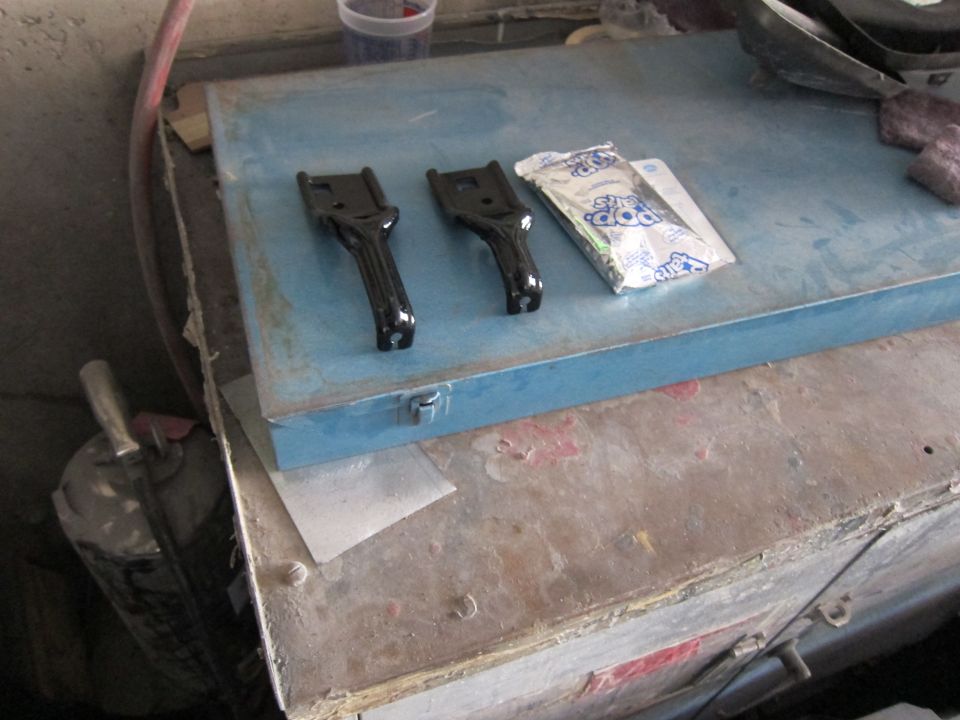 Two black metal brackets and a Pop Rocks candy packet on a blue toolbox