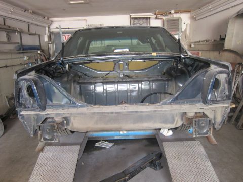 1991 Ford LTD Crown Victoria - The rear of a 1991 Ford Crown Victoria LTD is shown disassembled on a lift in a garage.