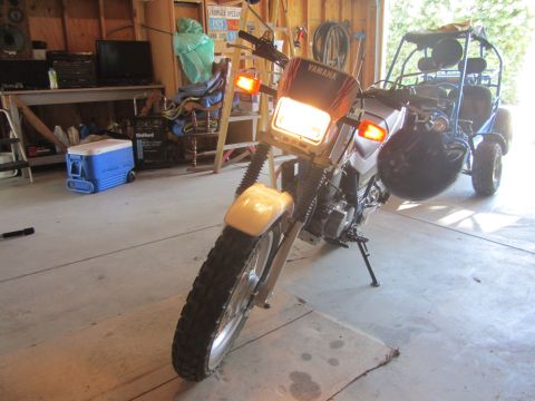 1968 Ford Mustang - Motorcycle and go-kart in a garage setting. The motorcycle has its headlights on.