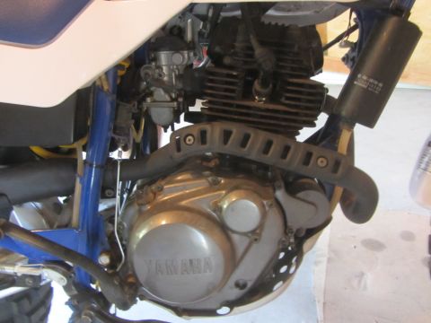 1968 Ford Mustang - Close-up view of a Yamaha motorcycle engine, showing the carburetor, exhaust, and engine casing.