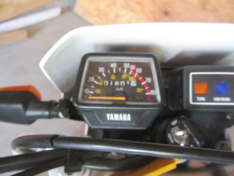 1968 Ford Mustang - Close-up of a Yamaha motorcycle's dashboard, the speedometer and indicator lights.