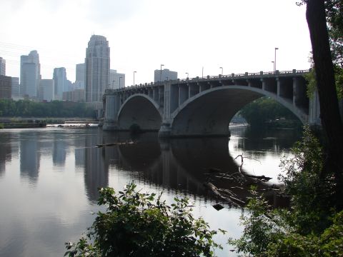 1992 Ford Taurus - A bridge spans a river, with a city skyline visible on the horizon and reflections in the water.