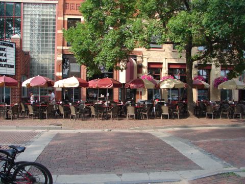 1992 Ford Taurus - An outdoor cafe scene with tables, chairs, and umbrellas, a bicycle is visible in the foreground.