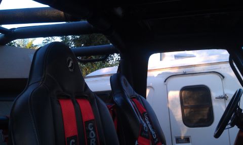 1978 Ford Bronco - Custom racing seats and roll cage are visible inside the vehicle, with a trailer seen through the side window.
