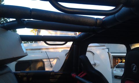 1978 Ford Bronco - View from inside a vehicle's roll cage shows a trailer and another car parked outside.