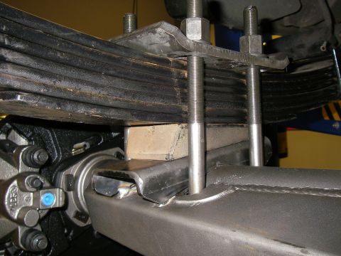 1990 Ford Bronco - This image shows a close-up view of a vehicle's suspension system, focusing on the leaf springs and axle attachment.