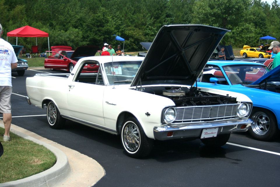 White 1976 Ford Ranchero with hood open, parked next to a blue car