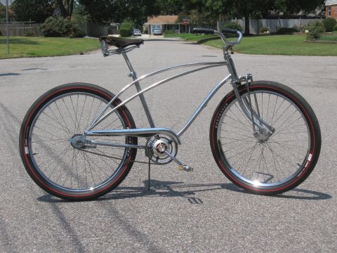 1994 Ford Bronco - A custom cruiser bicycle with a chrome frame and red-striped tires is shown parked on a residential street.