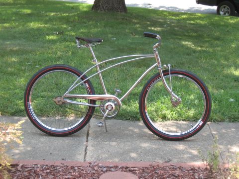 1994 Ford Bronco - A chrome cruiser bicycle with red-striped tires sits on a sidewalk.