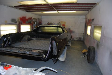 1975 Ford Ranchero - A black 1975 Ford Ranchero is parked inside a paint booth, ready for refinishing.