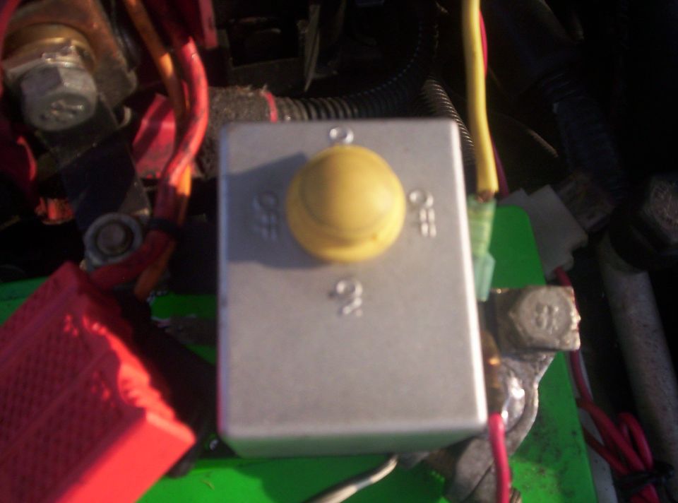 Aluminum box with yellow ON/OFF rotary knob mounted near battery in engine bay