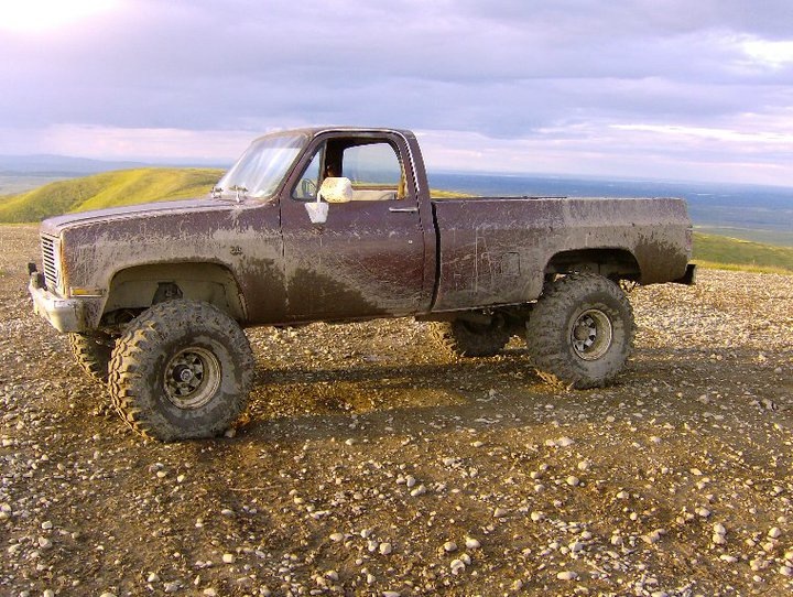 1983 Chevrolet C/K Pickup, side view, mud-covered with large tires