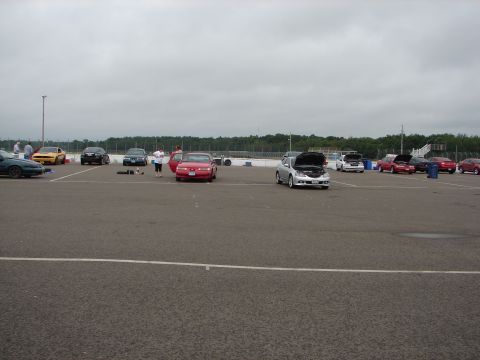 1992 Ford Taurus - Cars gathered at an outdoor event, with multiple vehicles visible on the asphalt lot.