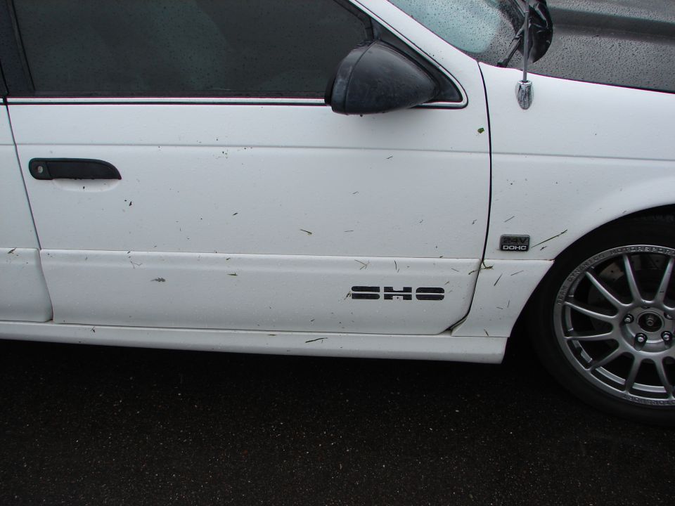 1992 Ford Taurus side view showing door handle, SHO badge, and alloy wheel