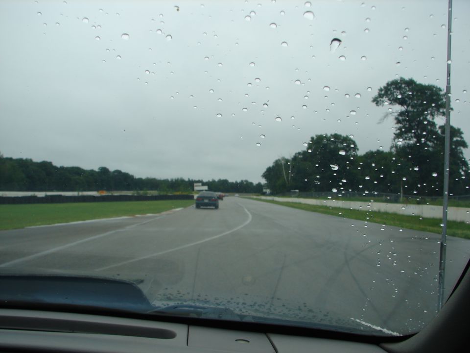 view from inside car on wet racetrack, other cars ahead