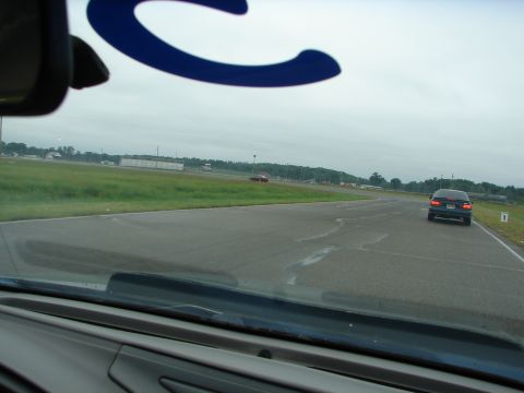 1992 Ford Taurus - Two cars are visible on a racetrack under an overcast sky.