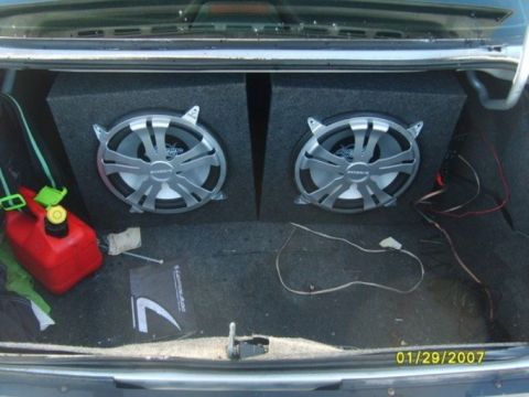 2000 Mercury Grand Marquis - The trunk of a car contains two large subwoofers and a red gas can.