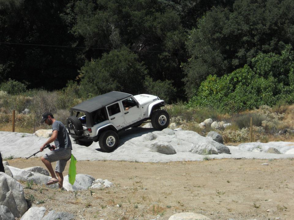 White Jeep Wrangler off-roading on rocks