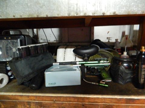 1995 Honda Civic - Various pieces of paintball gear are organized on a wooden shelf.