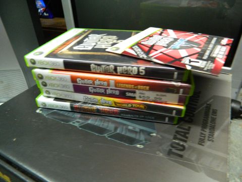 1995 Honda Civic - A collection of Xbox 360 game cases are stacked on top of a dark surface.