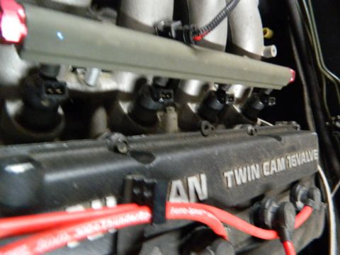 1995 Honda Civic - Close-up of a Nissan Twin Cam 16 Valve engine, showing fuel injectors and red spark plug wires.