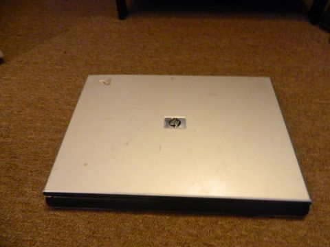 1995 Honda Civic - A closed silver HP laptop sits on a brown carpeted floor.