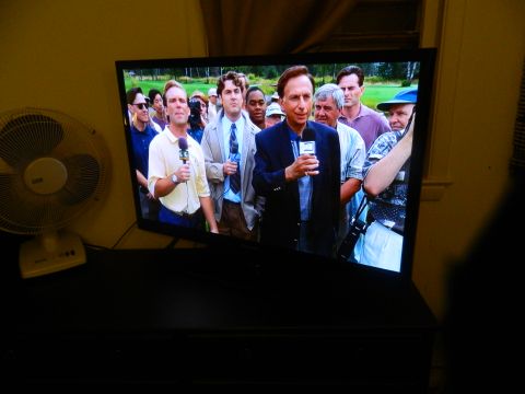 1995 Honda Civic - A television displays a news segment with a reporter holding a microphone and interviewing a crowd.