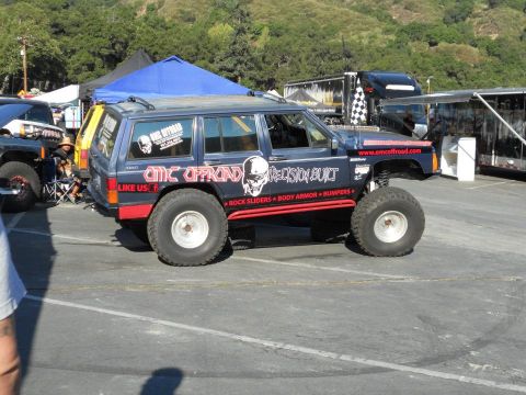 1986 Ford Bronco - A heavily modified Jeep Cherokee XJ with off-road modifications is parked in a lot.