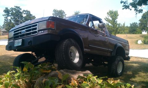 1987 Ford Bronco - This lifted 1987 Ford Bronco features an aftermarket bumper and is shown in a three-quarter front view.