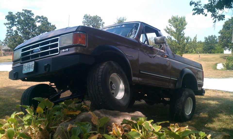 Brown 1987 Ford Bronco with lifted suspension and aftermarket bumper