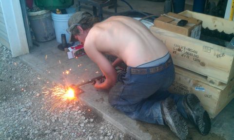 1987 Ford Bronco - A person is welding on a concrete surface, with sparks flying around them.