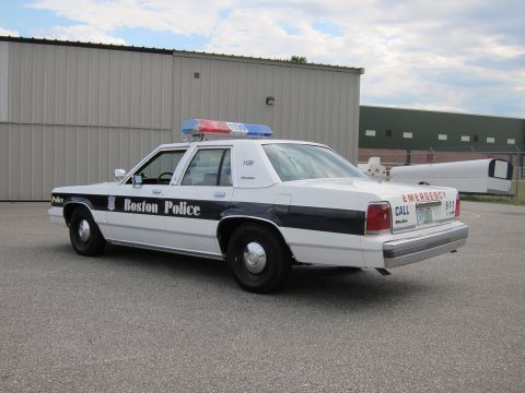 1991 Ford LTD Crown Victoria - A 1991 Ford Crown Victoria LTD police car, marked 'Boston Police', is parked outside a building.