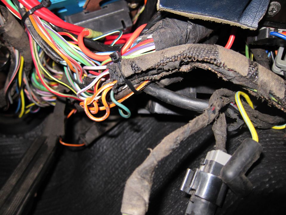 Tangled vehicle wiring harness with frayed insulation and zip ties